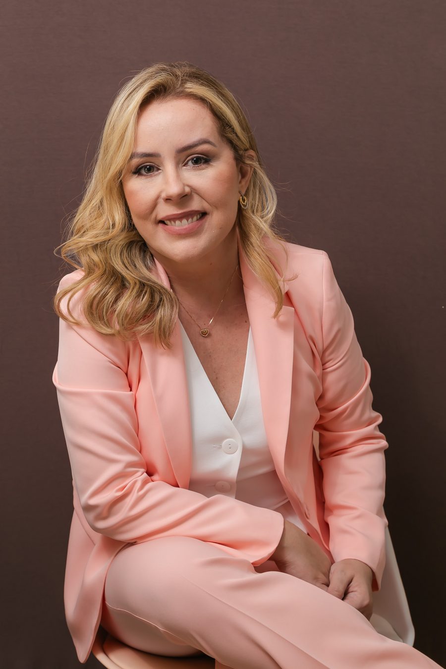Dra. Paula Brandão, cirurgiã vascular na Tijuca, Rio de Janeiro, de blazer rosa, sorrindo